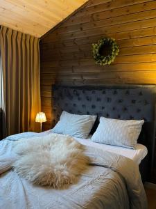 a bed with a white blanket on top of it at Moderne hytte ved sjøen med badstue in Rømskog