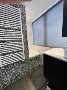 a bathroom with a shower and a tub and a sink at Room at the Beach Egmond in Egmond aan Zee