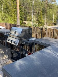 a grill sitting on a table on a deck at Moderne hytte ved sjøen med badstue in Rømskog
