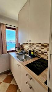 a kitchen with a sink and a view of the ocean at Apartment Memories II in Baška