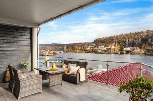 a balcony with furniture and a view of a body of water at The Nordic Escape - Oceanview - Hetlevik in Askøy