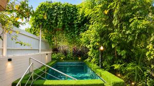 a swimming pool in a garden with plants at Gardens by Lotels in Madambakkam