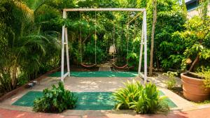 a playground with a swing in a garden at Gardens by Lotels in Madambakkam