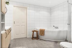 a white bathroom with a tub and a toilet at The Nordic Escape - Oceanview - Hetlevik in Askøy
