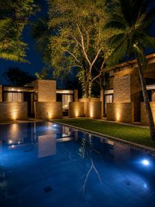 a villa with a swimming pool at night at Makham Villa River Kwai in Kanchanaburi City