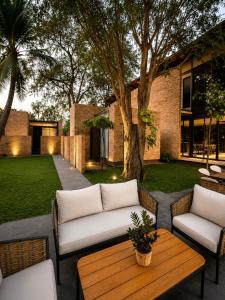 a patio with two couches and a table at Makham Villa River Kwai in Kanchanaburi City