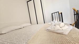 a bed with towels sitting on top of it at Apartment Memories II in Baška
