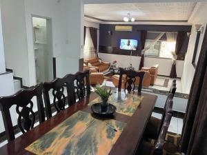 a dining room with a table and a living room at Villa le Dakota la différence in Yaoundé