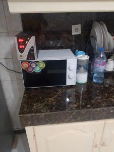 a microwave sitting on top of a kitchen counter at Villa le Dakota la différence in Yaoundé +2 photos