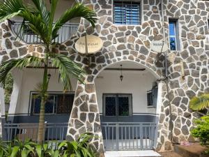 a building with a palm tree in front of it at Villa le Dakota la différence in Yaoundé