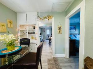 a dining room and kitchen with a glass table and chairs at Mango Beach House in Lake Worth