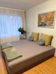 a bedroom with a bed with two pillows on it at Central Point Apartments in Rēzekne