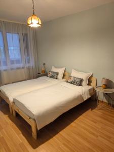 a bedroom with a large white bed with two pillows at Central Point Apartments in Rēzekne
