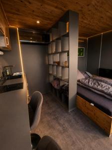 a small room with a bed and a chair at Seechalet Kranich in Roding