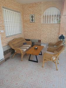 a living room with two chairs and a table at Casa ó Chalet Santiago de la Ribera San Javier VILLA ÍVALIS in Santiago de la Ribera
