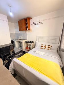 a bedroom with a large bed with a yellow blanket at Ruiru Cozy stays in Ruiru