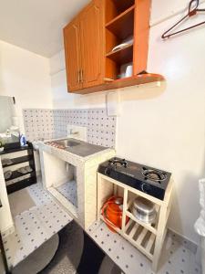 a miniature kitchen with a stove and a sink at Ruiru Cozy stays in Ruiru +2 photos