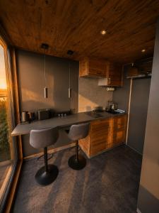 a kitchen with a counter and two bar stools at Seechalet Kranich in Roding