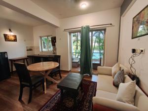 a living room with a couch and a table at Rajdeep by Dacha Arambol in Arambol