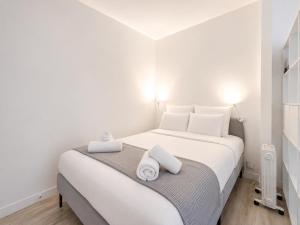 a bedroom with a white bed with towels on it at Le Ravissant - plage et casino à 2 min, Houlgate in Houlgate