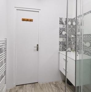 a bathroom with a white door and a shower at Le Ravissant - plage et casino à 2 min, Houlgate in Houlgate +12 photos