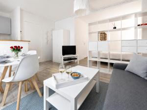 a living room with a couch and a table with wine glasses at Le Ravissant - plage et casino à 2 min, Houlgate in Houlgate