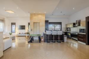 a large kitchen with a table and a living room at וילה הריביירה in Netanya