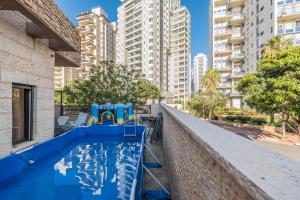 a swimming pool in the middle of a city with tall buildings at וילה הריביירה in Netanya
