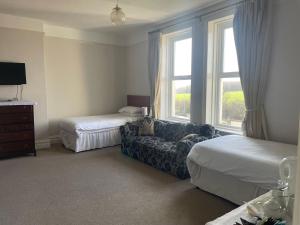 a bedroom with a couch and a bed and a window at Highland Moors in Llandrindod Wells +118 photos