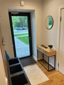 a door leading into a room with a desk and a mirror at Suite am Meer / Seaside suite in Ķesterciems +25 photos