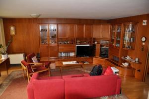 salon z czerwoną kanapą i telewizorem w obiekcie Ferienhaus Bifang w mieście Feldkirch