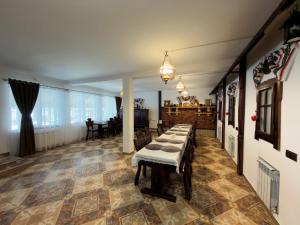 a dining room with a long table in a room at Casa Corlățeni in Pojorâta +62 photos