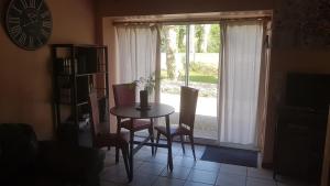 a dining room with a table and chairs and a window at Relaxing Gite aux fil de l'eau in Sainte-Colombe-sur-lʼHers