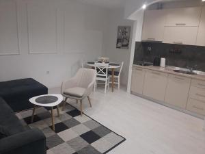 a kitchen and a living room with a couch and a table at Apartman Tijana in Pale +1 photo