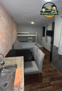 a living room with a couch and a sink in a room at Hospedagem e pizzaria florestinha in Búzios