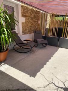 two chairs sitting on a patio with plants at Les chambres dhotes de la croix bleue 2 in Murinais