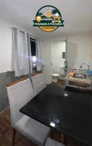a dining room with a table and a bathroom at Hospedagem e pizzaria florestinha in Búzios +4 photos