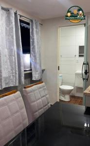 a bathroom with a toilet and a window at Hospedagem e pizzaria florestinha in Búzios