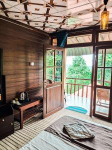 a bedroom with a bed and a wooden wall at Nice View Guest House & Restaurant in Ella