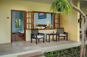 a patio with two chairs and a table and a room at Habana Angkor Resort in Siem Reap
