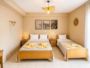 a bedroom with two beds and a chandelier at Mare Beachfront Rooms Himare in Himare