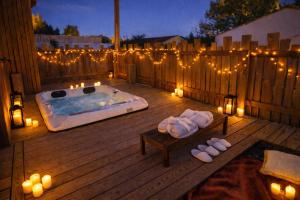 a deck with a hot tub with candles and lights at Les Gîtes de Laure - L'Eden Romantique, B&B, Spa privatif et Petit Déjeuner, Couloir de nage, 10mn Carcassonne in Malves