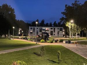a park at night with a playground and a building at Suite am Meer / Seaside suite in Ķesterciems