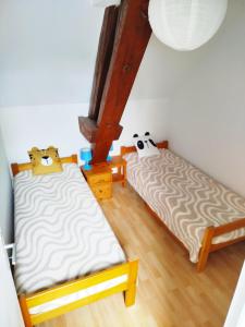 two twin beds in a room with wooden floors at Gîte Mézilles location sem-we in Mézilles