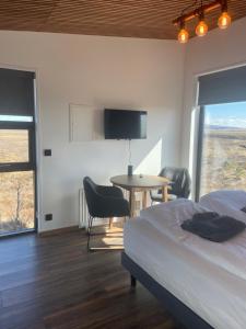 a bedroom with a bed and a table and a tv at Golden Circle Panorama Chalet in Selfoss