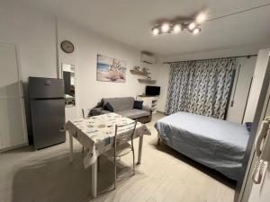 a room with a bed and a table and a kitchen at Monolocale 3 Api in Portoferraio