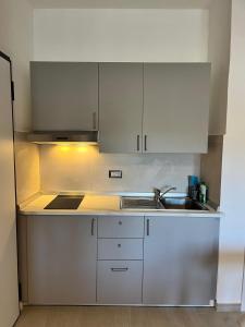 a kitchen with white cabinets and a sink at Monolocale 3 Api in Portoferraio