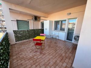 a patio with a yellow table and chairs on a balcony at Monolocale 3 Api in Portoferraio +2 photos
