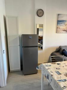a kitchen with a refrigerator and a clock on the wall at Monolocale 3 Api in Portoferraio