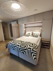 a bedroom with a large bed with a black and white comforter at Arte Güldenstubbe Residences in Kuressaare